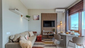 A modern living room with a sofa, TV, dining table, and chairs. - Alvor Bay Dream by Interhome (Alvor)
