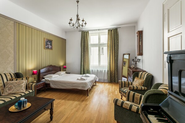 Una habitación de hotel con una cama, un piano, un sofá y una televisión.