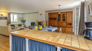 A compact living space with a kitchen area, a dining table, and a sofa. - Le Large by Interhome (Saint Philibert)