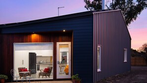 Una casa moderna con un'ampia porta vetrata che dà su cucina e sala da pranzo.