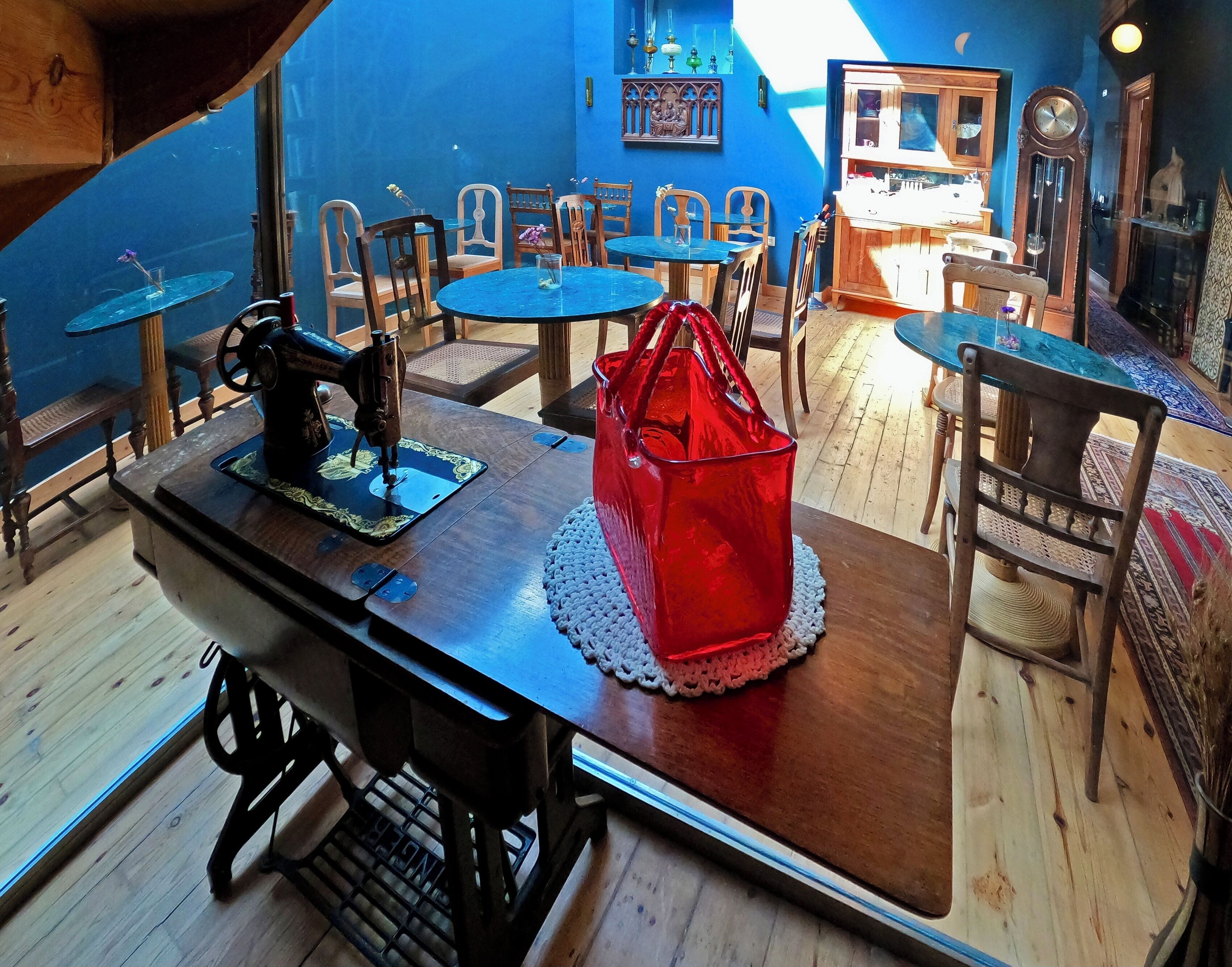A dining area with a wooden table, chairs, and a sewing machine.