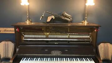 A grand piano with two upright stands, a saxophone, and a sign reading "Aristodemus".