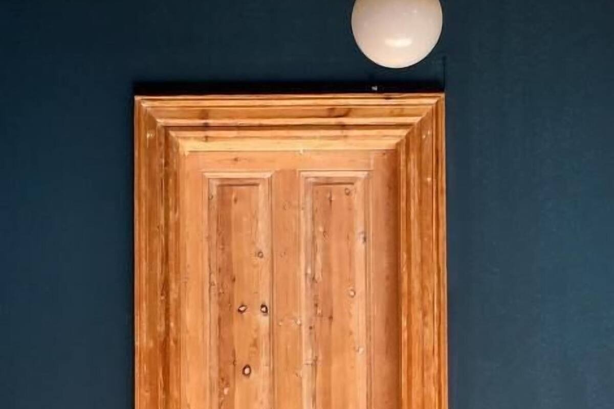 A wooden door with a round light fixture above it.