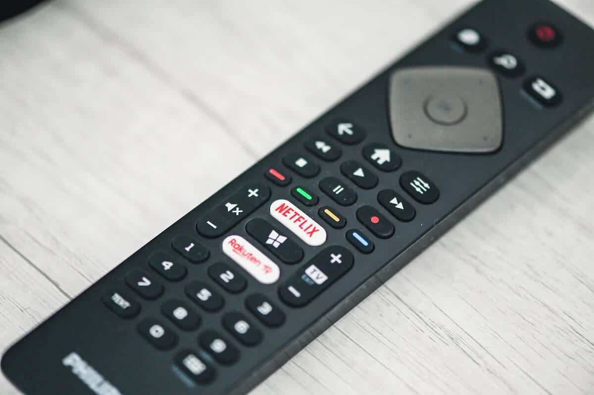 A remote control with a large central button and directional pad.