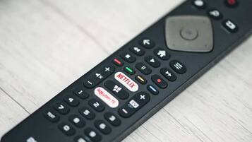 A remote control with a large central button and directional pad.