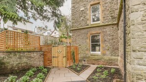 A stone building with a wooden gate, a small window, and raised garden beds. - Belle Vue (Hereford)