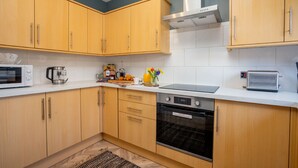 Eine Küche mit Holzausstattung, einer Mikrowelle, einem Toaster und einem Herd.