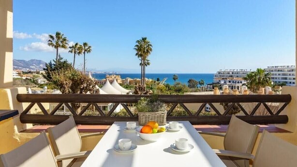 Mesa para dos con vista al mar y palmeras.