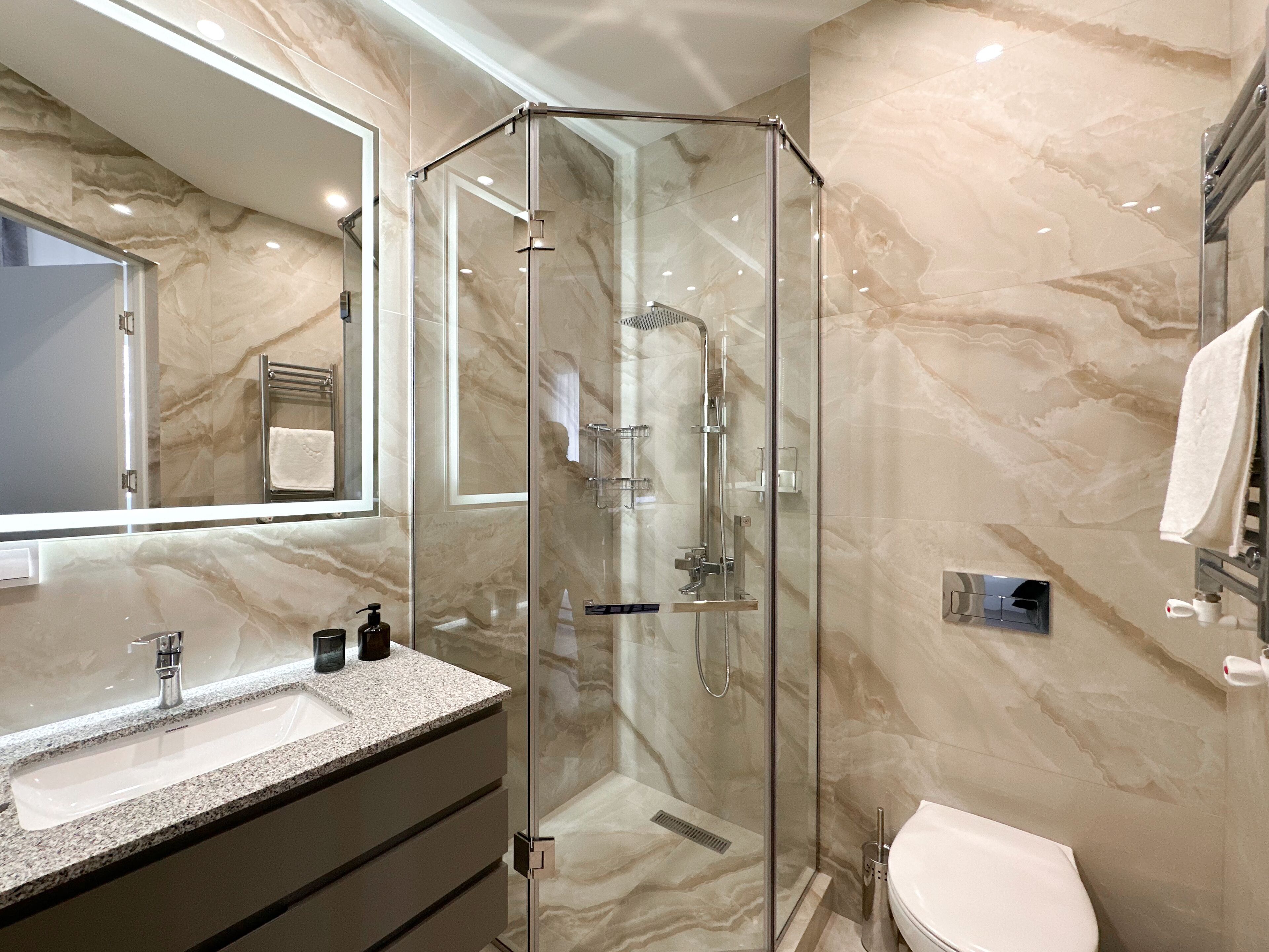 City appartement | Badkamer | Een douche, een regendouche, gratis toiletartikelen, een haardroger
