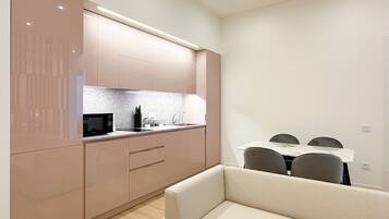 A modern kitchen with a microwave, sink, and cabinets. There is a dining area with a table and chairs.