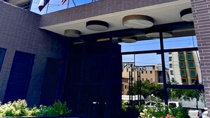 Fachada de edificio con tres banderas: estadounidense, francesa y china.