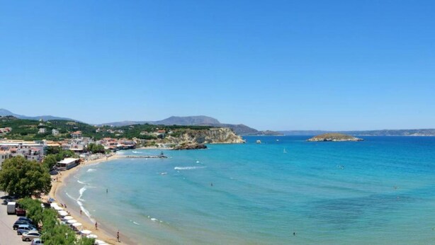 A coastal town with a beach, clear blue sea, and hills in the background. - Cost Mari Boutique Hotel  (Apokoronas)