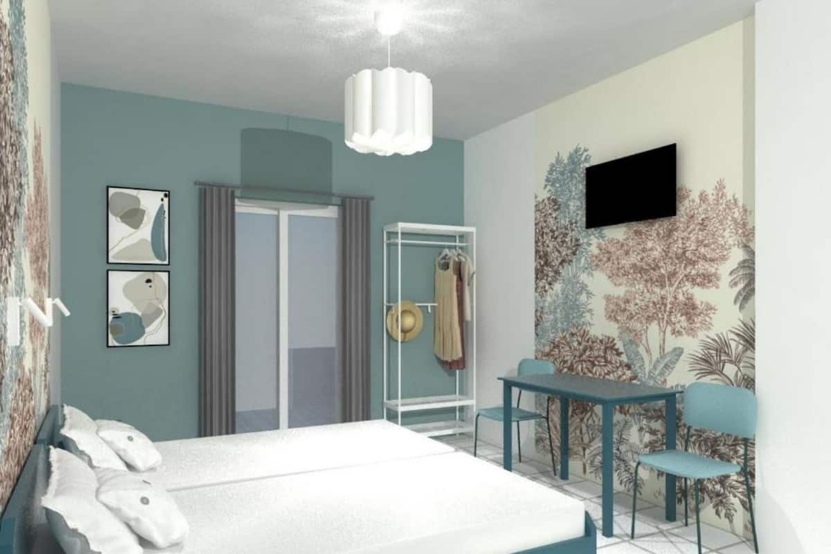 Une chambre à coucher avec un lit, un bureau, une chaise, une armoire et un téléviseur fixé au mur.
