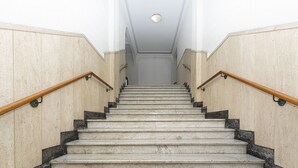 A staircase with marble steps and wooden handrails, leading to a door at the top. - In the Heart of Santa Margherita by Wonderful Italy (Santa Margherita Ligure)