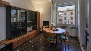 A compact living space with a dining area, a built-in TV, and a large window offering a city view. - In the Heart of Santa Margherita by Wonderful Italy (Santa Margherita Ligure)