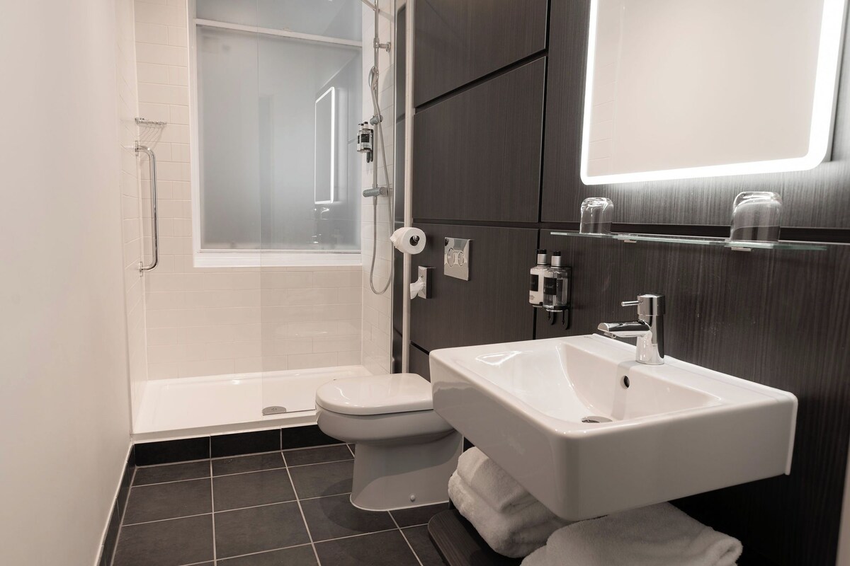A modern bathroom with a bathtub, toilet, and sink.