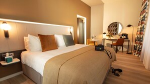 A modern hotel room with a large bed, bedside table, and a desk with a chair. - The Address Glasgow (Glasgow)