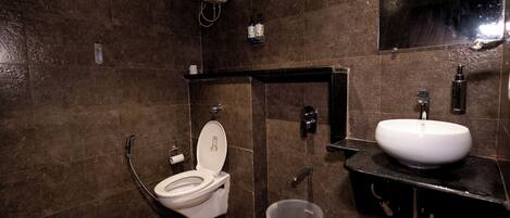 A modern bathroom with a toilet, sink, and hand dryer.