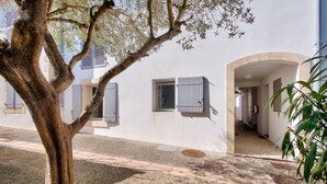 A building with a white exterior, a tree in the foreground, and a gravel pathway. - 150m from St Martin de Ré harbour, studio for 2 (Saint-Martin-de-Ré)