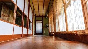 Ein traditioneller japanischer Raum mit Tatami-Böden, Schiebetüren und einer Holzziel.
