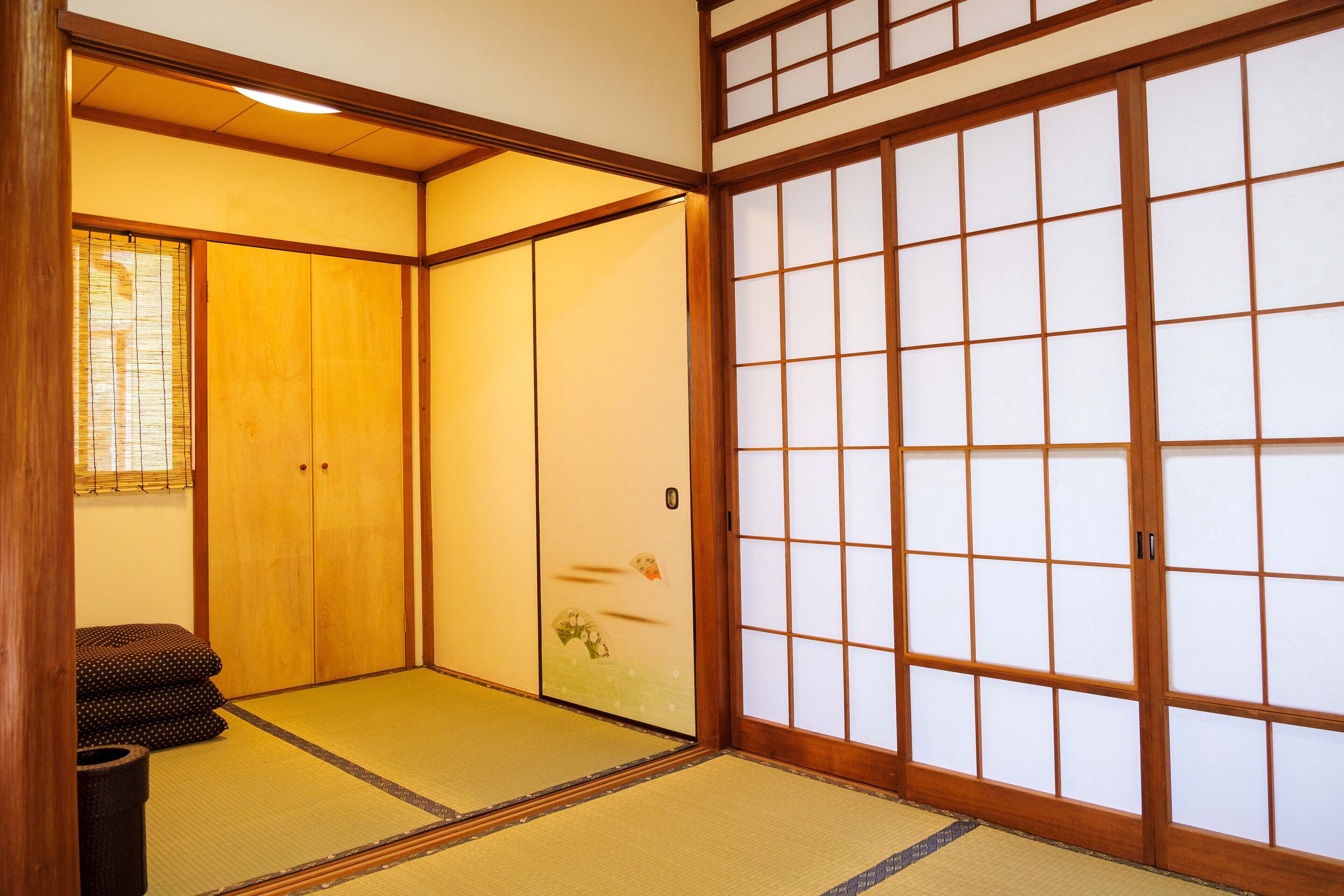 Ein traditioneller japanischer Raum mit Tatami-Böden, Schiebetüren und einem niedrigen Holztisch.