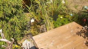 A wooden deck with a pond and surrounding vegetation. - Sigrid's vacation apartment Bad Tölz (Bad Tölz)