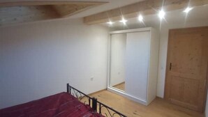 A room with a bed, a wooden door, and a white closet. - Sigrid's vacation apartment Bad Tölz (Bad Tölz)