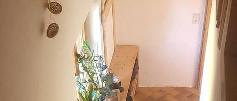 A wooden staircase leading to a room with a herringbone floor pattern.