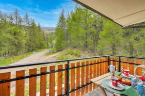 A balcony with a view of a forested area and a dirt path. - Studio Abete Rosso 500m From Ski (Sauze d'Oulx)