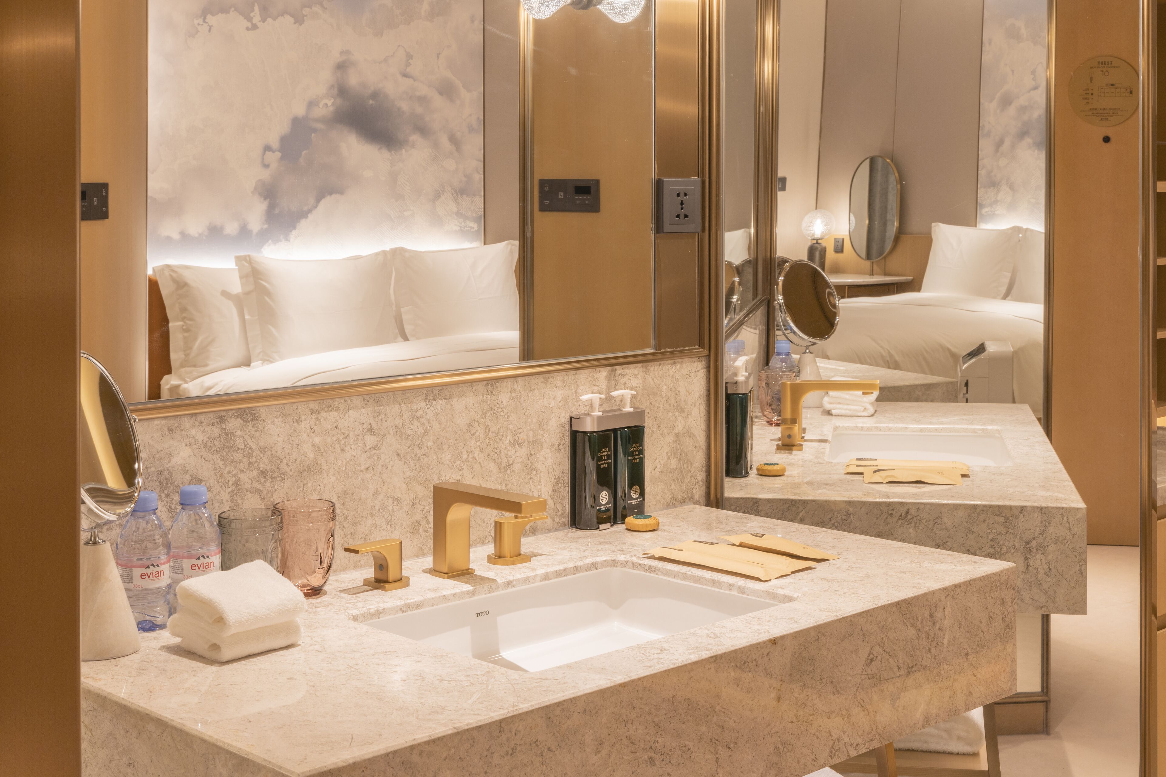 Un baño de hotel con un espejo grande, un lavabo y una zona de ducha.