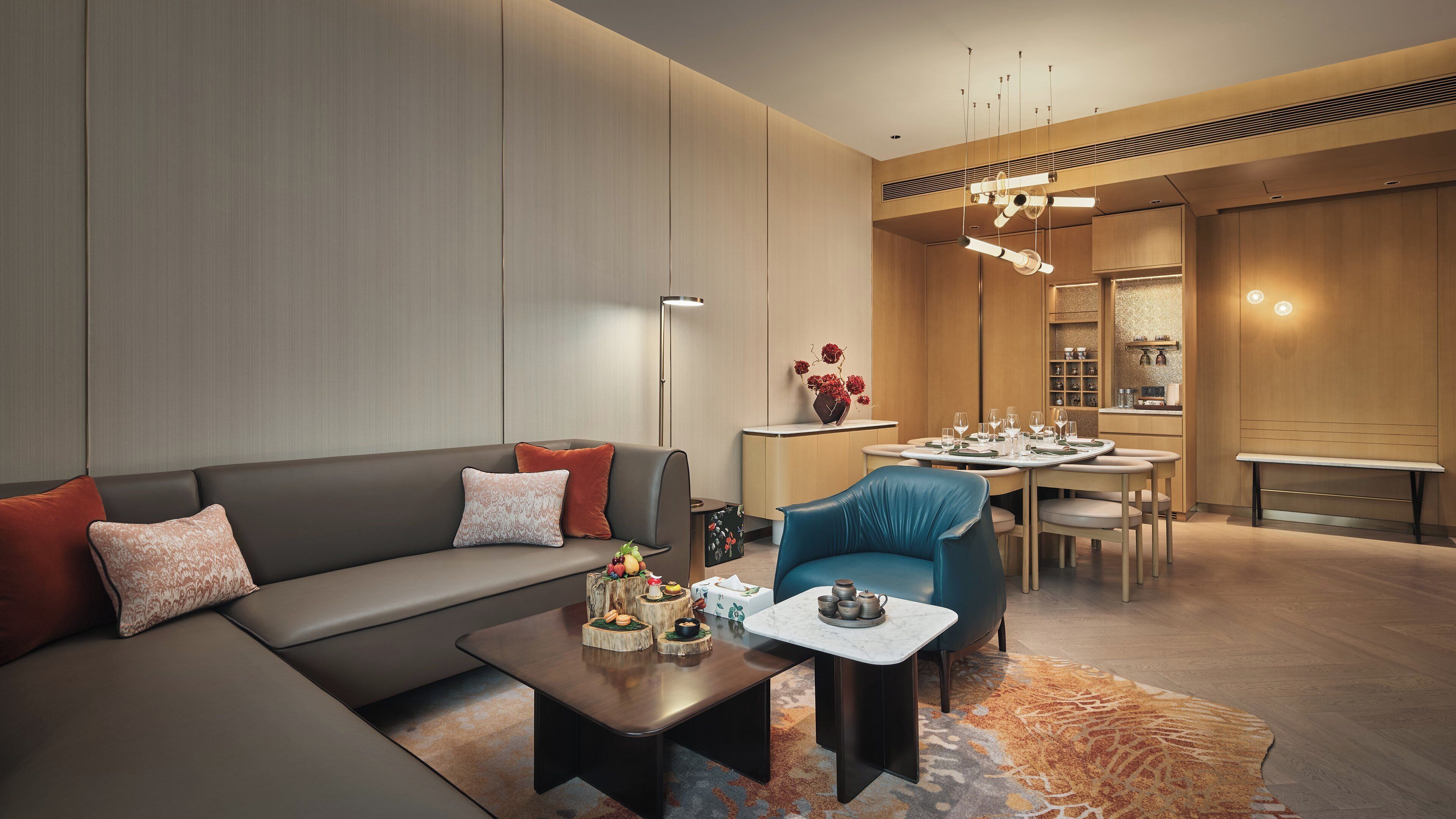 A modern living room with a sofa, coffee table, and a dining area with a table set for four.