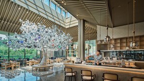 A modern interior with a central decorative tree, a bar area, and a spacious seating arrangement. - Hotel Indigo Hangzhou Tianmushan by IHG (Hangzhou)