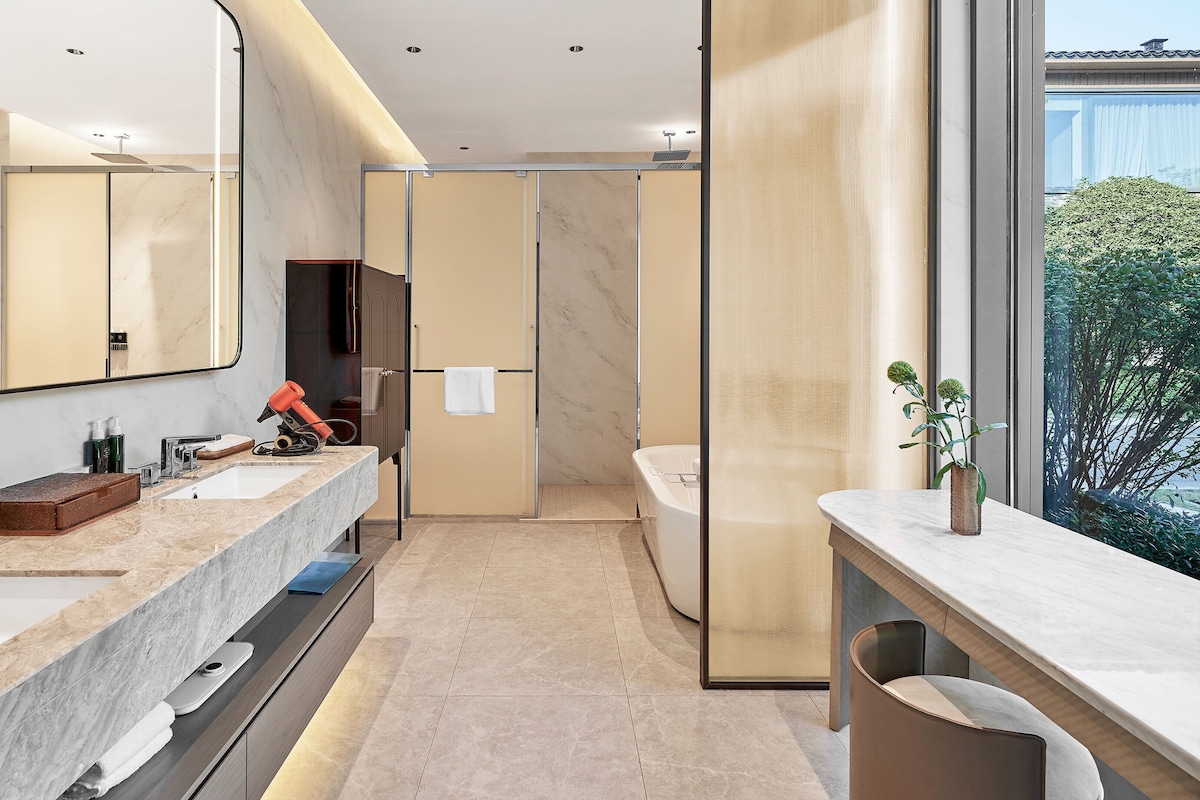 Une salle de bain moderne dotée d’un grand miroir, de deux vasques et d’un espace douche.