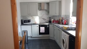 A compact kitchen with a microwave, oven, and washing machine. - 10 minutes from the local beach great surfing beach
License Nr.HI-00282-F (Thurso)