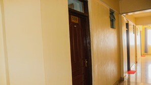 Un pasillo con una puerta de madera con el número 506, que da a una habitación.