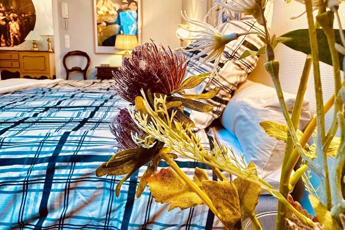 Une chambre à coucher comprenant un lit, une table de chevet, une chaise et une lampe fixée au mur.