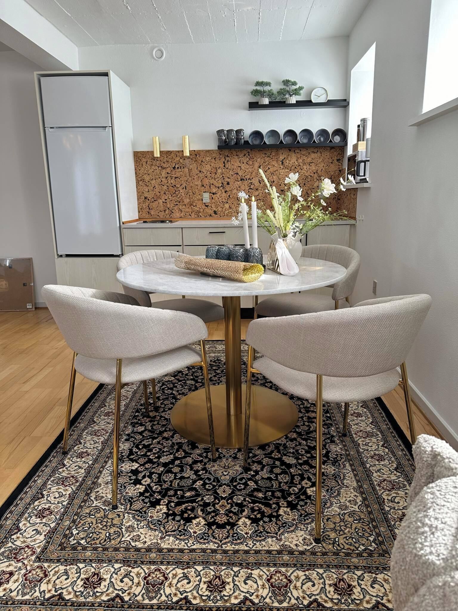 A dining area with a round table, four chairs, and a decorative centerpiece.