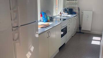 A modern kitchen with white cabinets, a built-in oven, and a window above the sink.