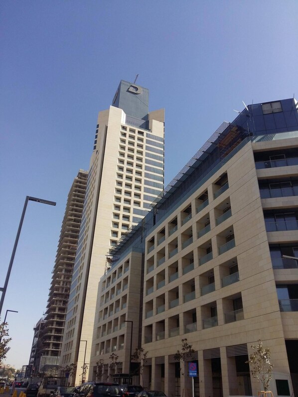 A multi-story building with a modern architectural design, featuring a prominent 'R' logo on the top.
