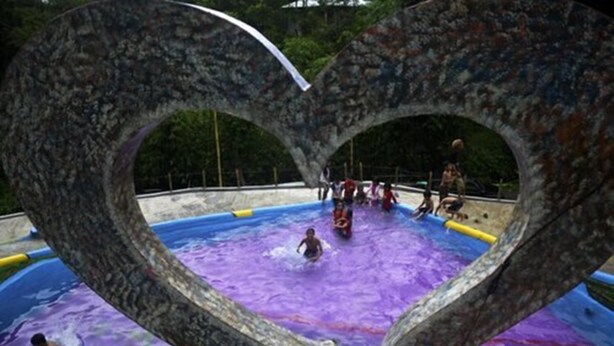 Ein Swimmingpool mit einer herzförmigen Bogenkonstruktion.
