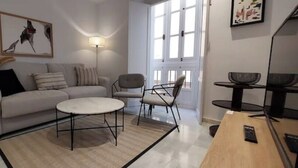 Ein modernes Wohnzimmer mit Sofa, Ohrensessel, Couchtisch und einem kleinen Beistelltisch.