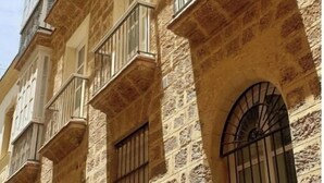 Um edifício de vários andares com fachada de pedra e varandas.