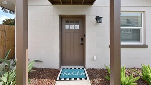 A house with a brown door, a 'hello' mat, and a wooden fence. - Quiet Studio Guesthouse in Jax - Near Downtown (Jacksonville)