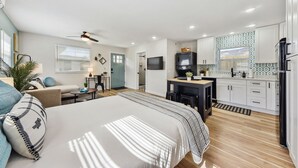 A modern bedroom with a large bed, a desk, and a TV. - Quiet Studio Guesthouse in Jax - Near Downtown (Jacksonville)