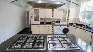Une cuisine moderne équipée d’une cuisinière à gaz, d’un four à micro-ondes et d’un lave-linge encastré.