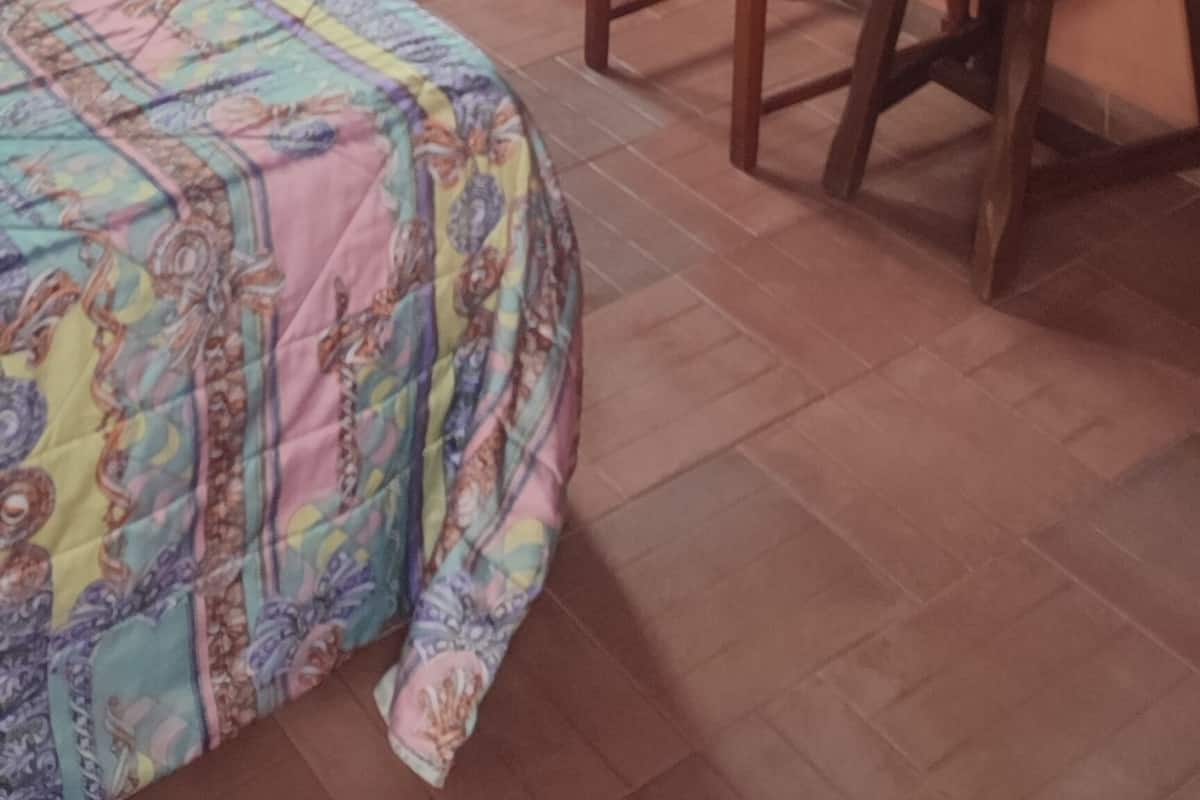 A room with a bed, a chair, and a table.