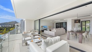 A modern living space with a balcony, white furniture, and a dining area. - Penthouse  Apt Colomer by JS Villas (Port de Pollença)