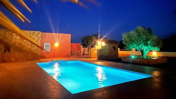 A swimming pool at dusk with surrounding buildings and a tree. - Exclusive Finca with Pool – Away from Mass Tourism – Peaceful Location! (Triquivijate/Antigua)