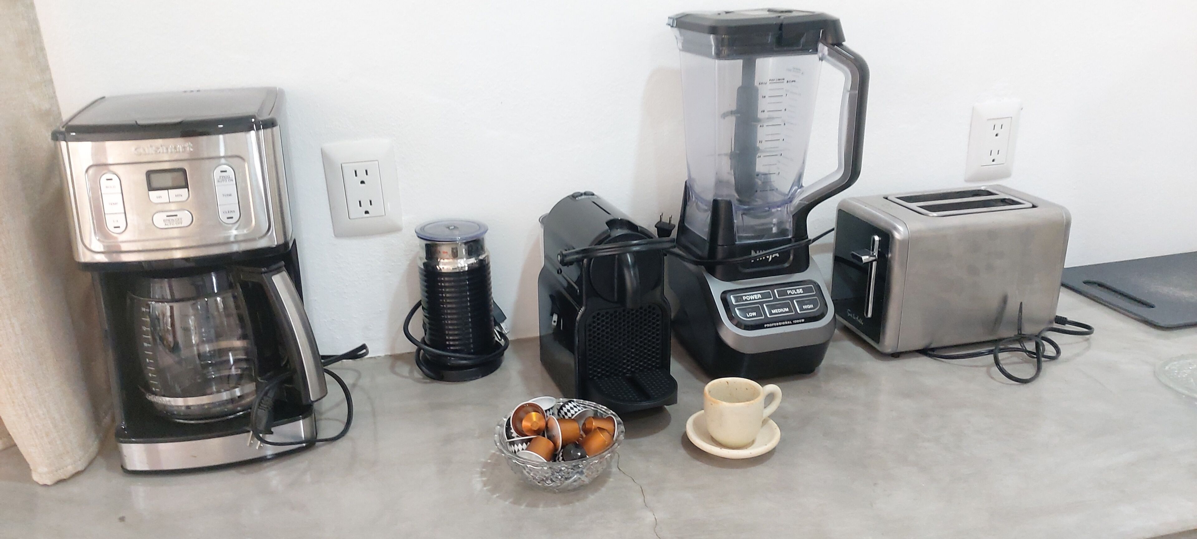 Eine Küche mit Kaffeemaschine, Mixer, Toaster und einer Schüssel mit Kaffeebohnen.