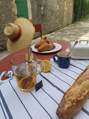 A table set with a glass of tea, a baguette, a croissant, a cup, and a straw. - "Nouveau, a true haven of peace near Saint-Emilion, Bordeaux. (Saint-Vincent-de-Pertignas)